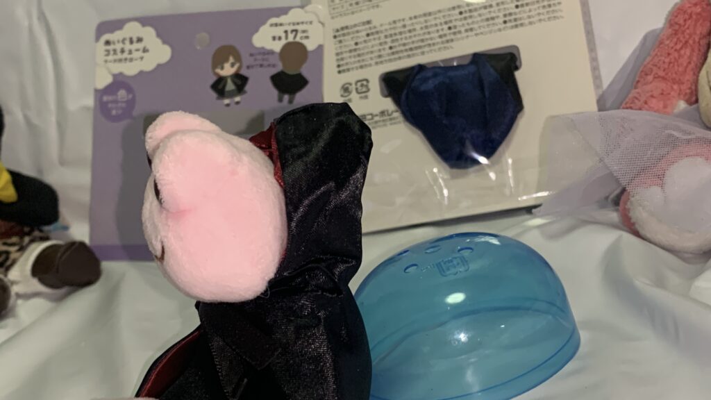 フード付きローブを着たかえるのピクルスのマスコットの後ろ姿