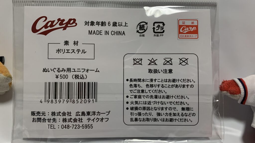 ぬいぐるみ用ユニフォームのパッケージ裏面。税込500円、素材ポリエステル、取り扱い注意の表示