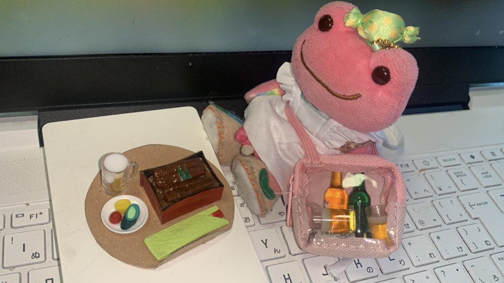 ミニチュアのケーキやお菓子の食品サンプルを並べて撮影したかえるのピクルス