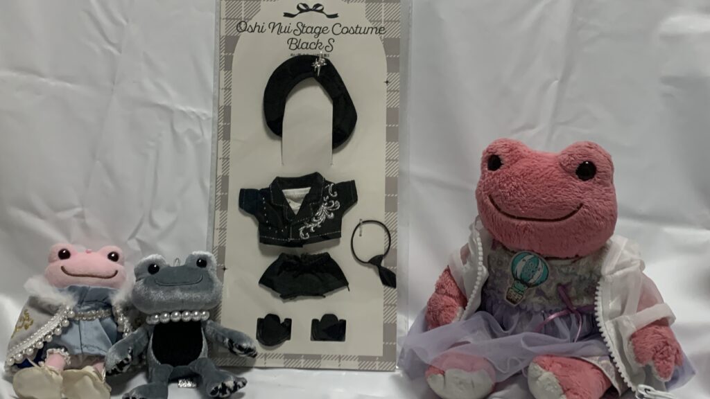 スリーコインズのぬい服 ステージ衣装黒：Sのパッケージと、かえるのピクルスたち