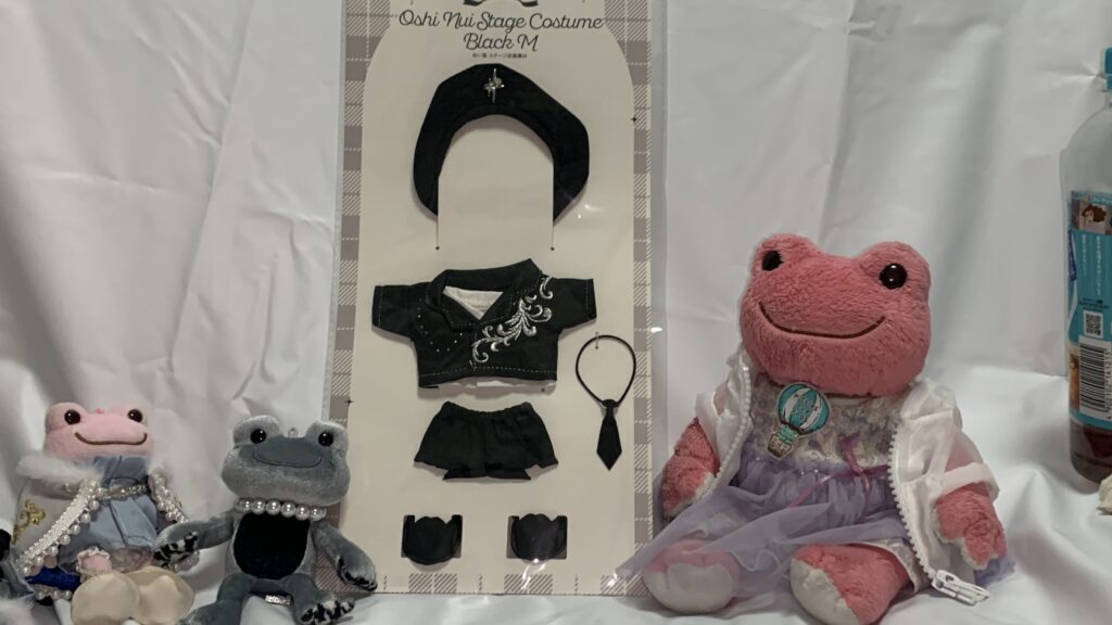 スリーコインズのぬい服 ステージ衣装黒：Mのパッケージと、かえるのピクルスたち